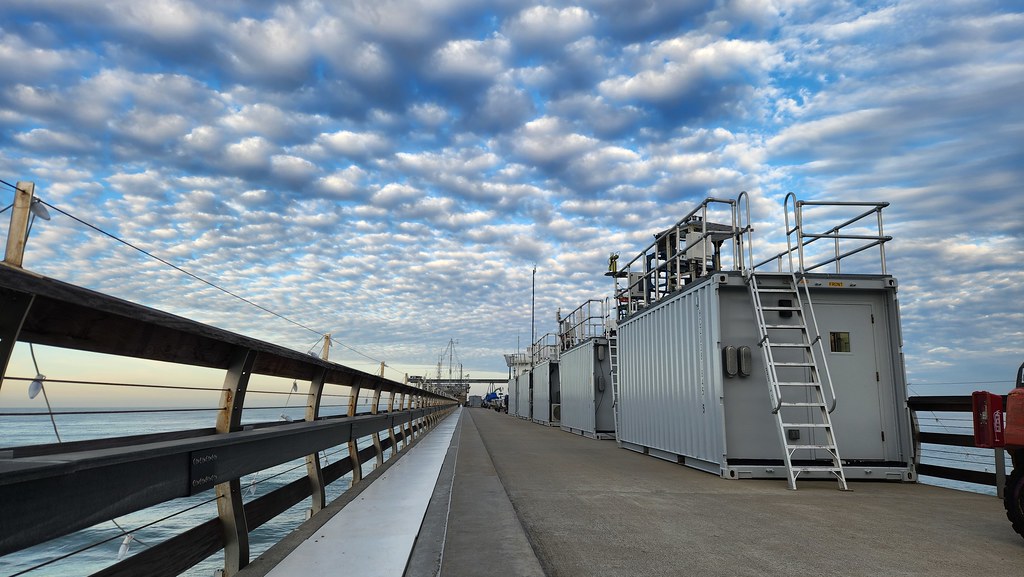 Atmospheric instrument containers on an ocean pier.