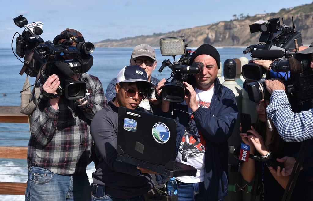 In February 2023, during an EPCAPE media day in La Jolla, California, Hamelmann Communications technician Ana Gabriela “Gabi” Pessoa explains data on her laptop. EPCAPE allowed researchers like Smith to compare shoreline data with those from instruments high up on nearby Mt. Soledad. Pessoa was part of both the TRACER and EPCAPE deployments. Photo by Gary Geernaert. U.S. Department of Energy.